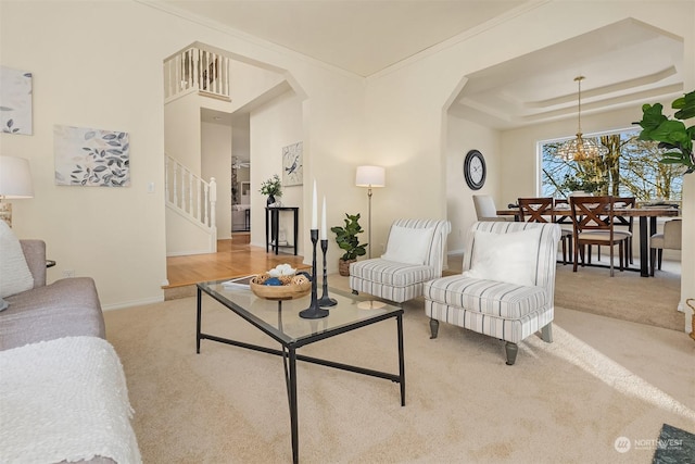 carpeted living room with crown molding and a tray ceiling