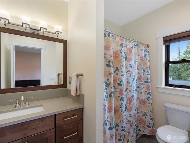 bathroom featuring toilet, vanity, and a shower with curtain