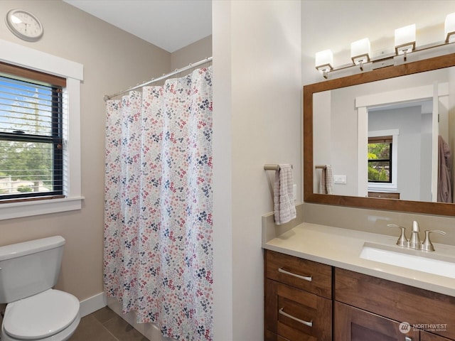 bathroom featuring tile patterned flooring, toilet, plenty of natural light, and vanity