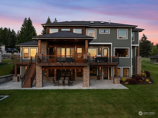 back of property at dusk with a yard and a patio area