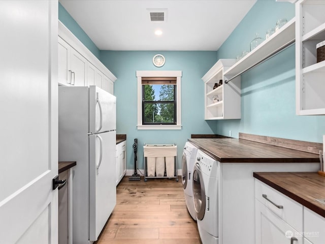 laundry area featuring visible vents, baseboards, recessed lighting, light wood-style flooring, and washer and dryer