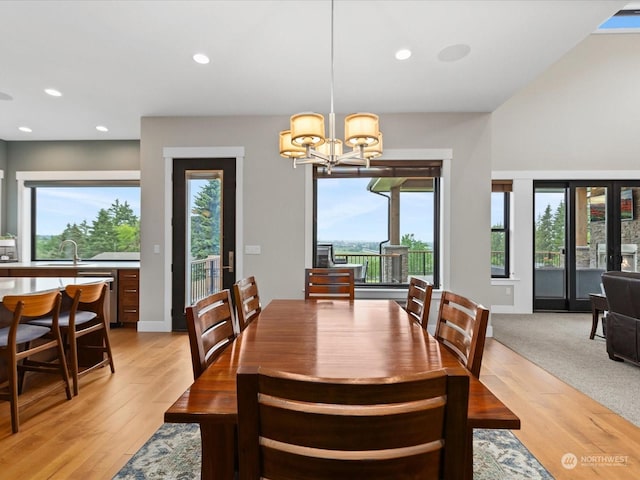 dining space with a notable chandelier, recessed lighting, light wood-style flooring, and baseboards