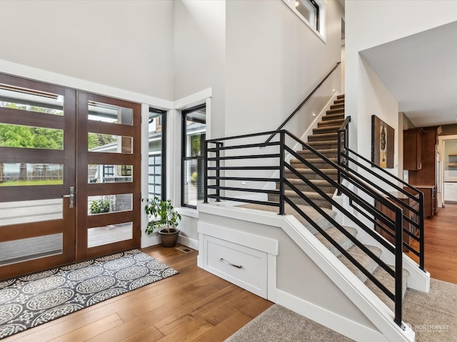entryway featuring stairway, a high ceiling, and wood finished floors