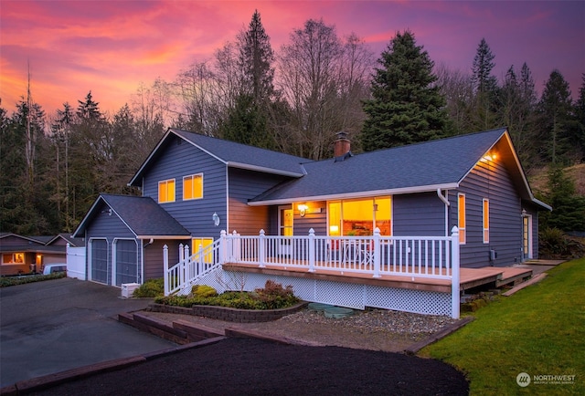 view of front facade featuring a garage, a lawn, and covered porch