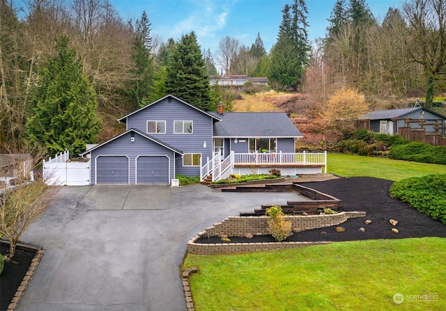 view of front of property with a garage, covered porch, and a front lawn