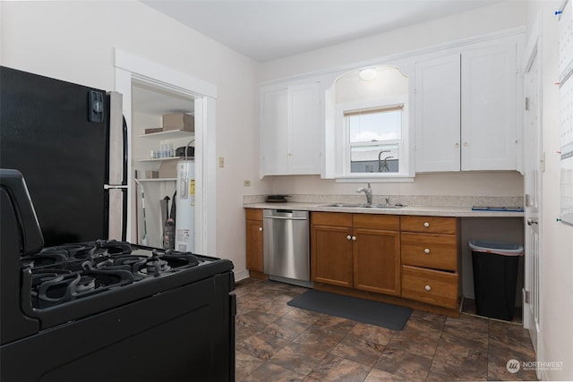 kitchen featuring white cabinetry, sink, water heater, and appliances with stainless steel finishes