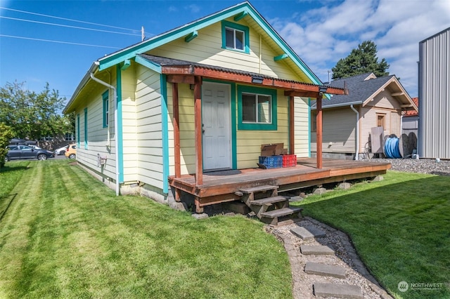 rear view of property featuring a deck and a lawn