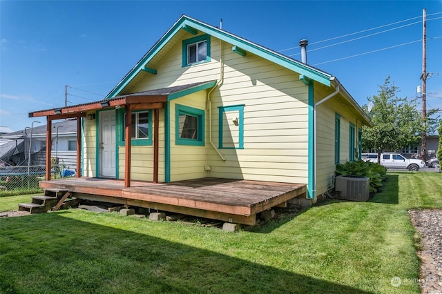 back of house featuring central AC unit, a yard, and a wooden deck