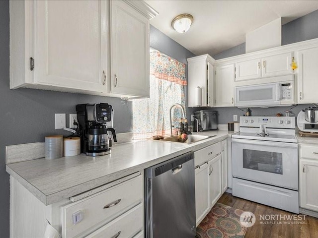 kitchen featuring dark hardwood / wood-style floors, sink, white cabinets, and white appliances