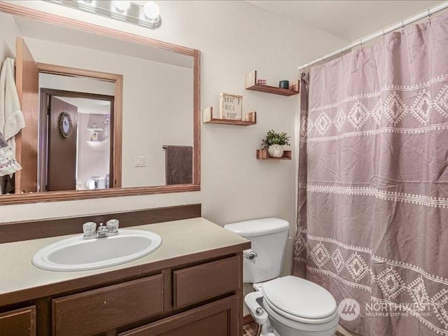 bathroom with vanity, curtained shower, and toilet