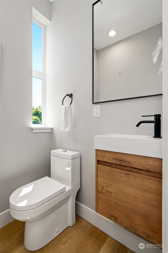 bathroom with vanity, toilet, and hardwood / wood-style floors