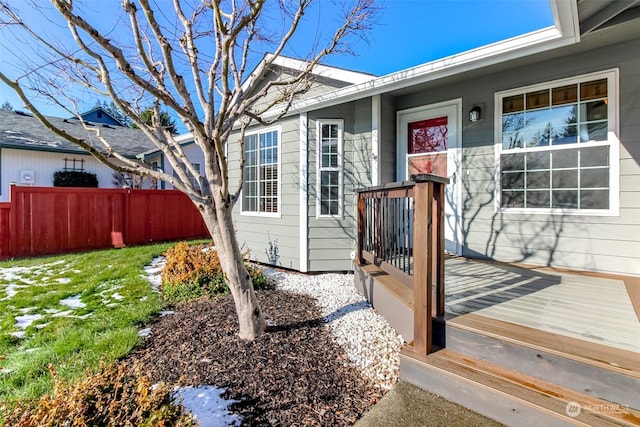 doorway to property with a lawn and a deck