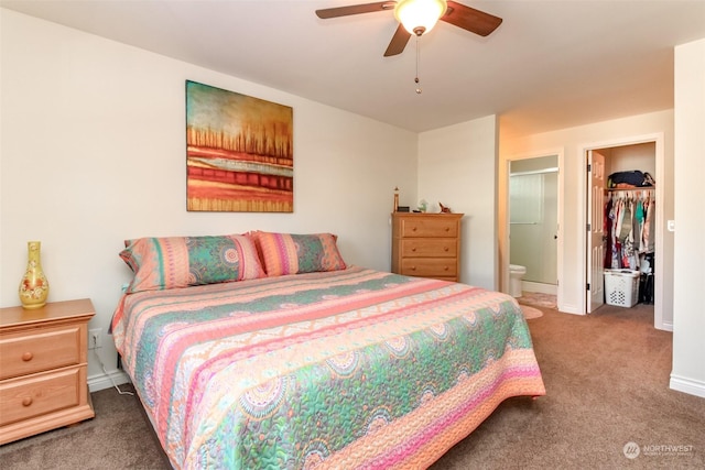 carpeted bedroom with ceiling fan, a spacious closet, ensuite bath, and a closet