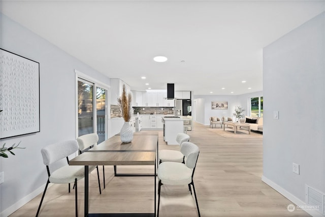 dining area with a healthy amount of sunlight and light hardwood / wood-style floors