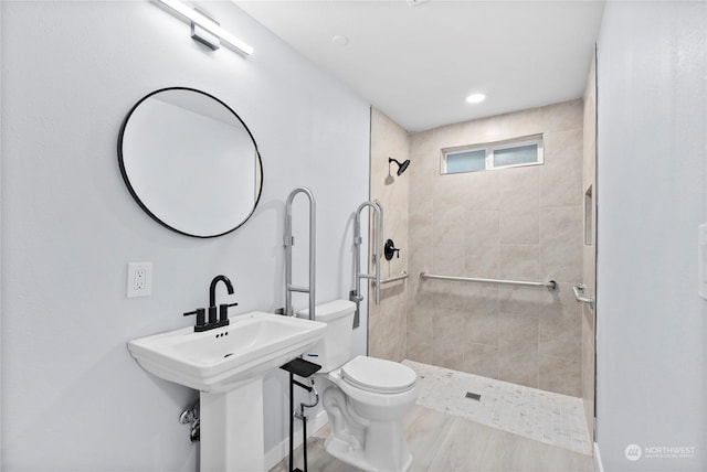 bathroom featuring tiled shower and toilet