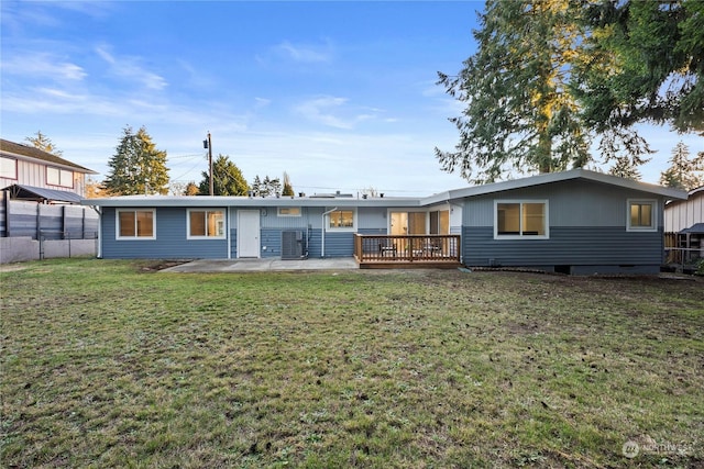 back of house with a wooden deck and a lawn