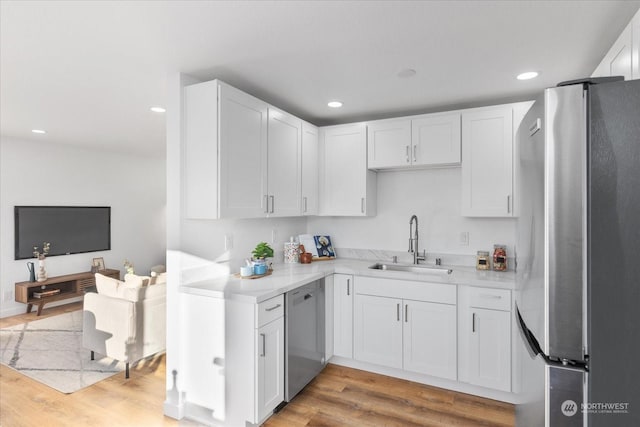 kitchen with white cabinetry, appliances with stainless steel finishes, sink, and light wood-type flooring