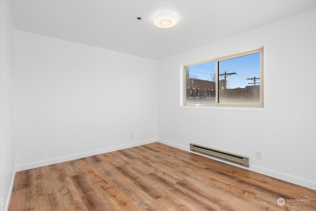 unfurnished room with a baseboard radiator and wood-type flooring