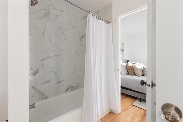 bathroom with hardwood / wood-style flooring and shower / bath combination with curtain