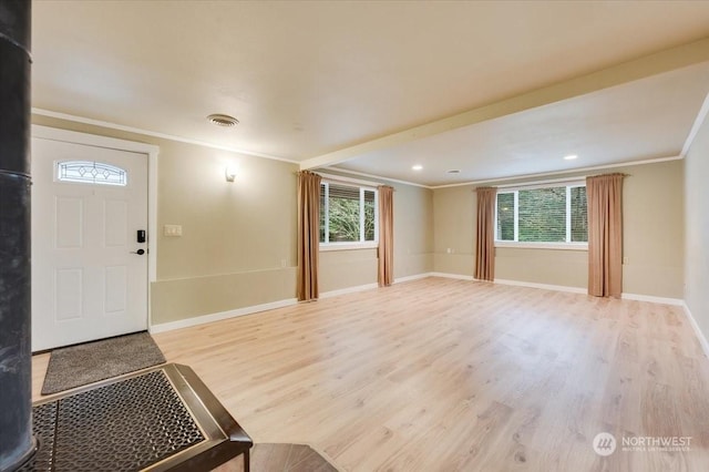 entrance foyer featuring light hardwood / wood-style flooring, ornamental molding, and a healthy amount of sunlight