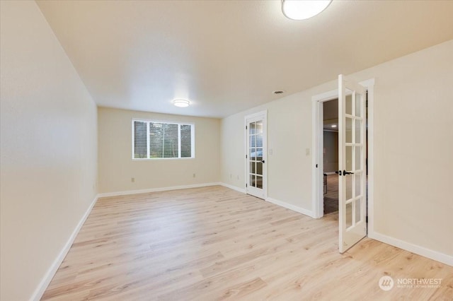 empty room featuring light wood-type flooring and french doors