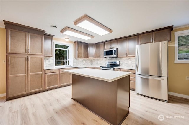 kitchen featuring tasteful backsplash, a wealth of natural light, stainless steel appliances, and a center island