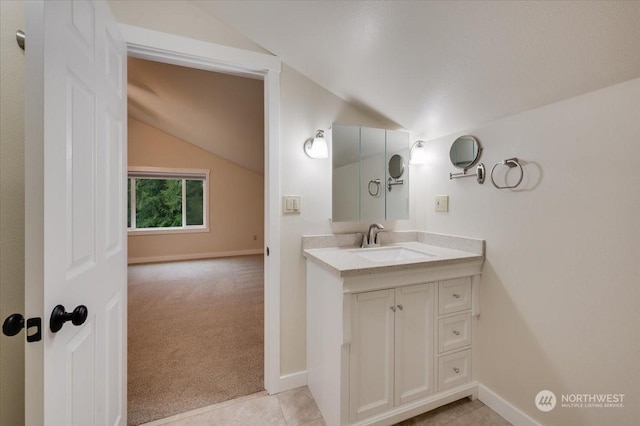 bathroom with vanity, tile patterned flooring, and vaulted ceiling