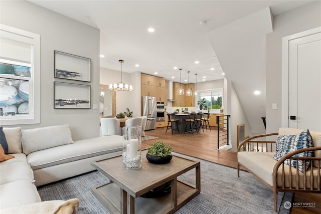 living room with a chandelier and light wood-type flooring