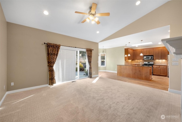 unfurnished living room featuring high vaulted ceiling, light colored carpet, and ceiling fan