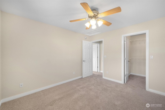 unfurnished bedroom featuring a spacious closet, light carpet, ceiling fan, and a closet