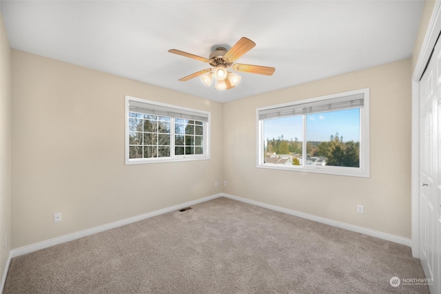 spare room with light colored carpet and ceiling fan