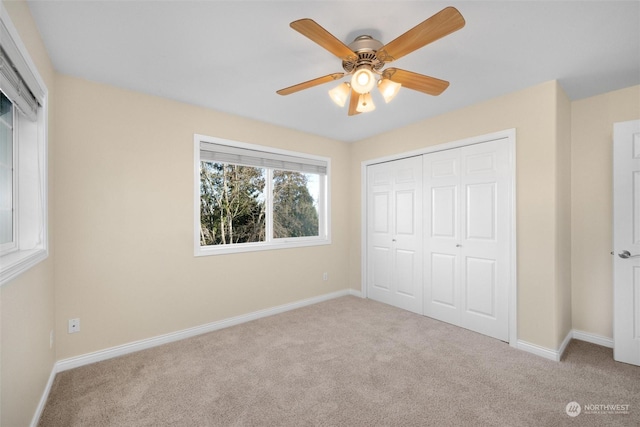 unfurnished bedroom featuring light colored carpet, ceiling fan, and a closet