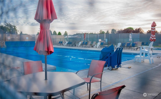 pool at dusk with a patio