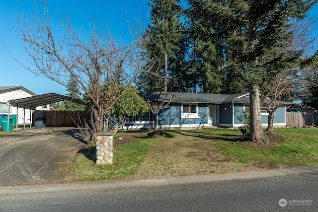 ranch-style home featuring a carport and a front yard