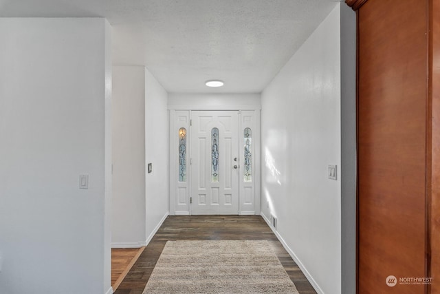 foyer featuring dark hardwood / wood-style flooring and a textured ceiling