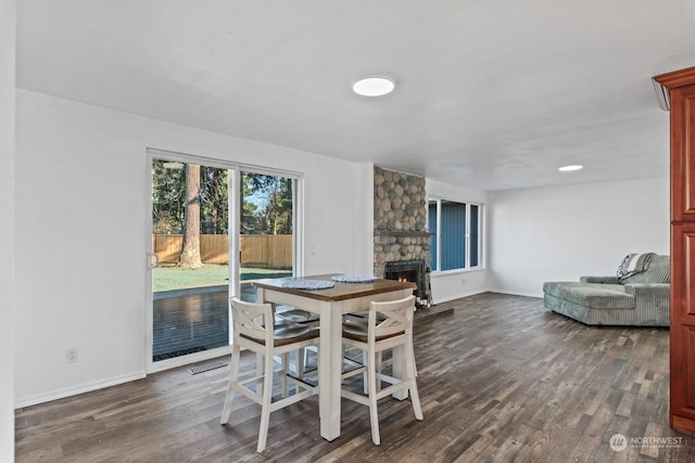 dining space with dark hardwood / wood-style flooring and a fireplace