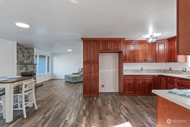 kitchen featuring dark hardwood / wood-style flooring and a stone fireplace