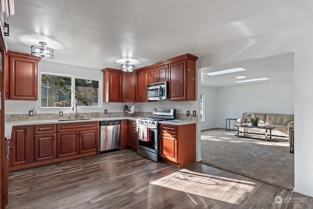 kitchen featuring stainless steel appliances, dark hardwood / wood-style floors, sink, and a textured ceiling