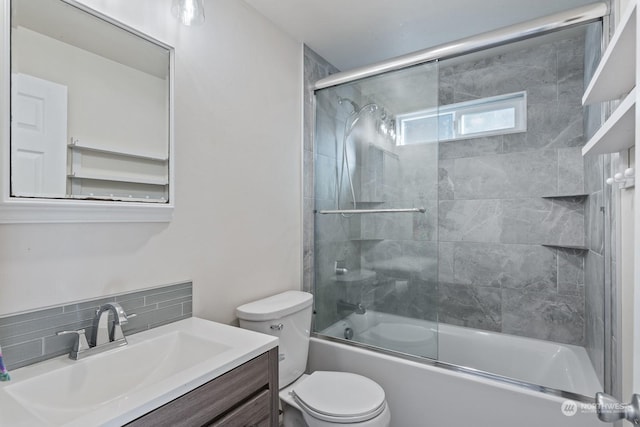 full bathroom with vanity, decorative backsplash, shower / bath combination with glass door, and toilet