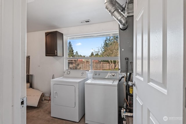 clothes washing area featuring cabinets and independent washer and dryer