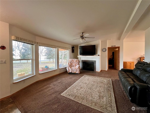 carpeted living room with ceiling fan and a tile fireplace