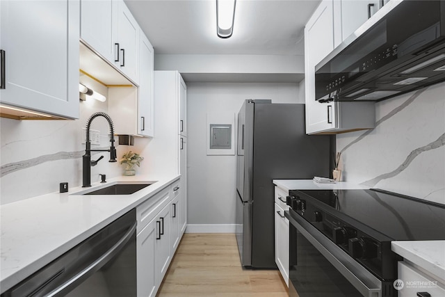 kitchen with sink, black appliances, white cabinets, and light wood-type flooring