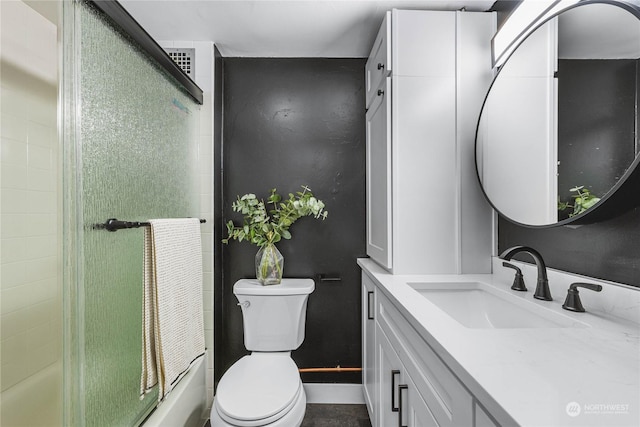 bathroom featuring vanity, an enclosed shower, and toilet