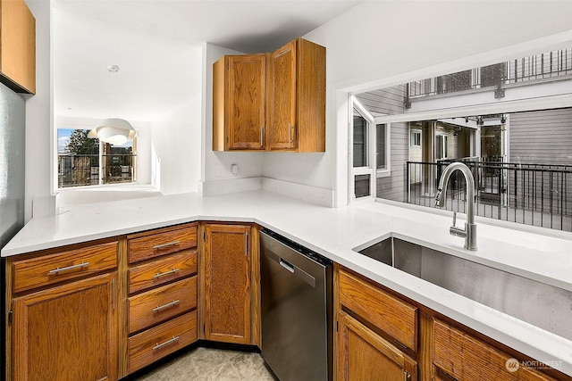 kitchen featuring sink, decorative light fixtures, and stainless steel dishwasher