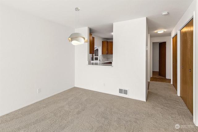 unfurnished room featuring sink and light colored carpet