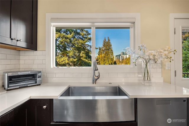 kitchen featuring dark brown cabinetry, sink, and backsplash