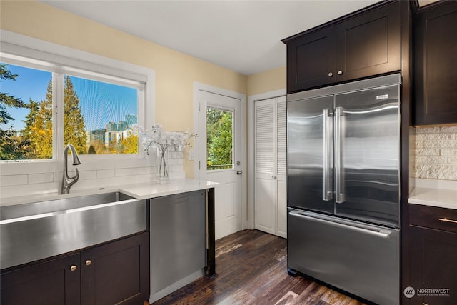 kitchen with stainless steel appliances, dark hardwood / wood-style floors, sink, and backsplash