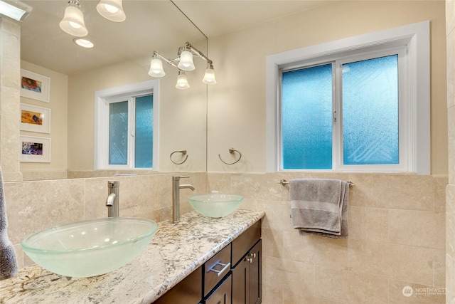 bathroom featuring vanity and tile walls