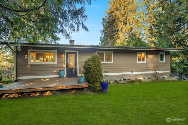 rear view of property with a wooden deck and a yard