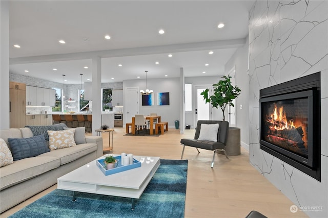 living room featuring a high end fireplace and light wood-type flooring